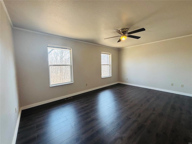 empty room with visible vents, crown molding, baseboards, dark wood-style floors, and a ceiling fan