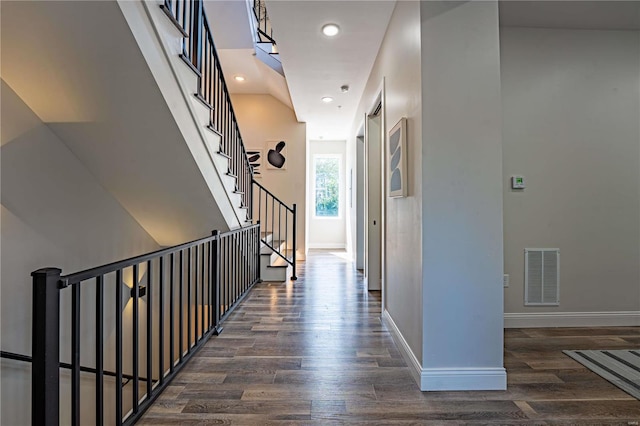 hallway featuring dark wood finished floors, recessed lighting, baseboards, and visible vents