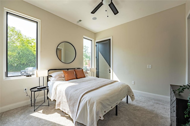 carpeted bedroom with visible vents, baseboards, and ceiling fan