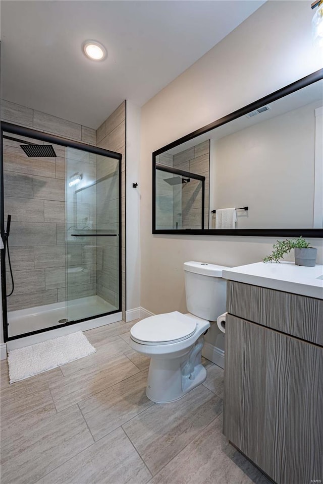 bathroom featuring a shower stall, toilet, and visible vents