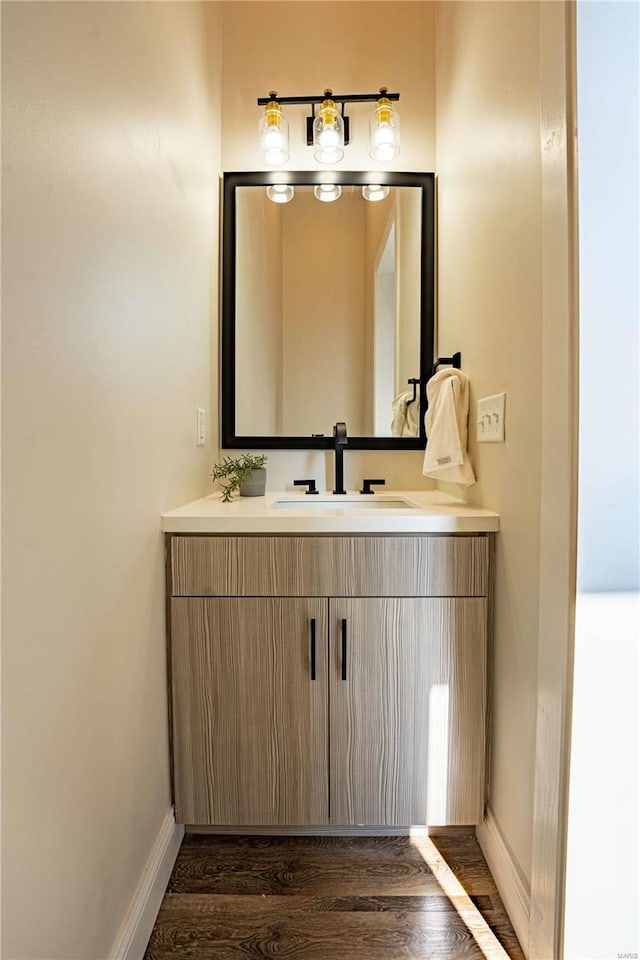 bathroom featuring vanity, wood finished floors, and baseboards