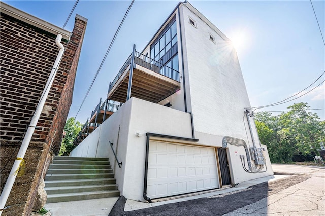 view of side of home featuring stucco siding and stairway