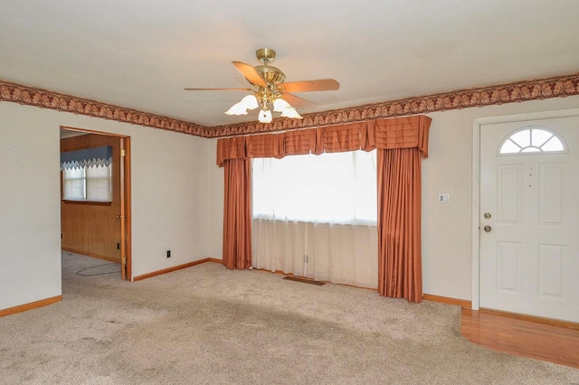 entrance foyer with baseboards, carpet floors, and a ceiling fan