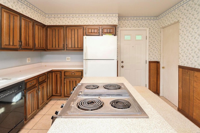 kitchen featuring wallpapered walls, dishwasher, light countertops, and freestanding refrigerator