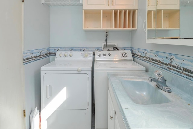 laundry area with cabinet space, washing machine and dryer, and a sink