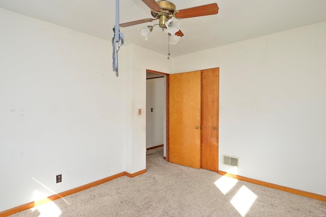 empty room featuring visible vents, baseboards, carpet, and a ceiling fan