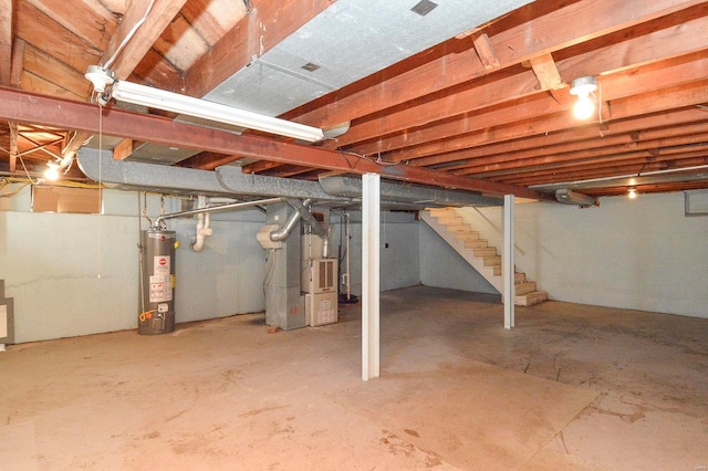 unfinished basement with gas water heater, stairway, and heating unit