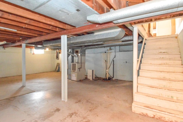 basement featuring heating unit and stairs