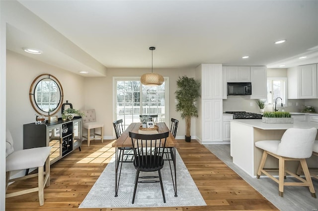 dining space with light wood finished floors, recessed lighting, and baseboards