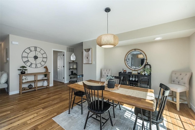 dining space with visible vents, baseboards, and hardwood / wood-style floors