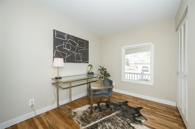 home office with baseboards and wood finished floors