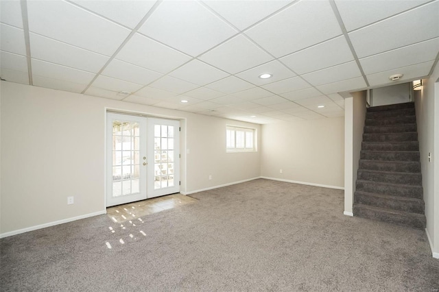 below grade area with stairway, french doors, baseboards, and carpet floors