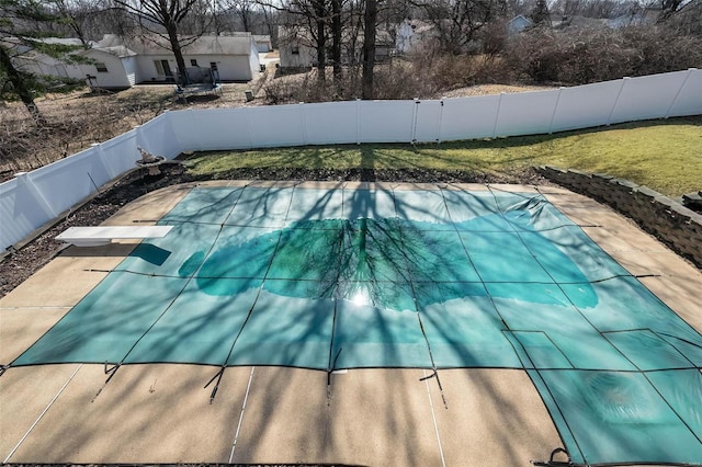 view of swimming pool with a diving board, a fenced in pool, and a fenced backyard