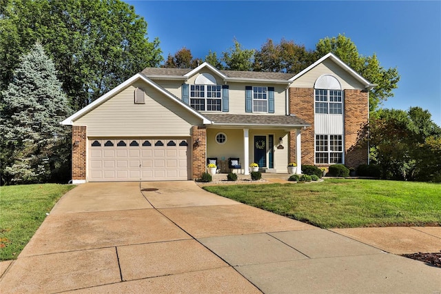 traditional home with a front yard, a garage, brick siding, and driveway