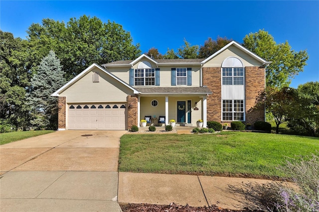 traditional-style home featuring a front yard, an attached garage, covered porch, concrete driveway, and brick siding