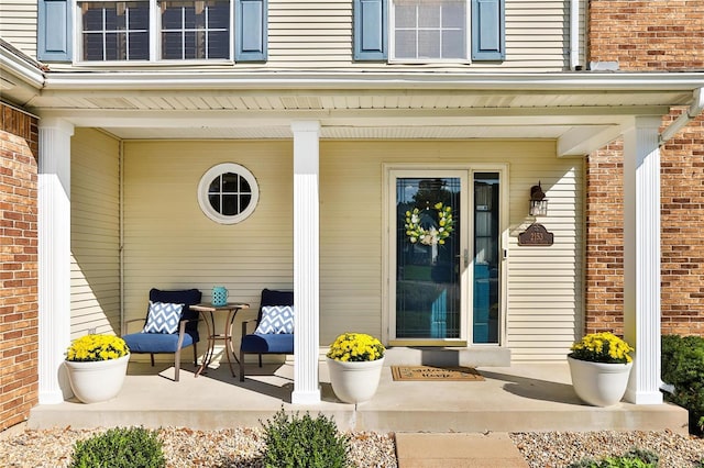 property entrance with brick siding and covered porch