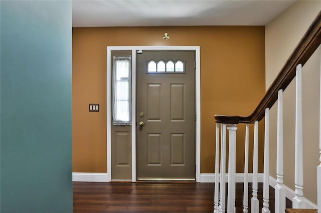 foyer entrance with stairway, baseboards, and dark wood-style flooring