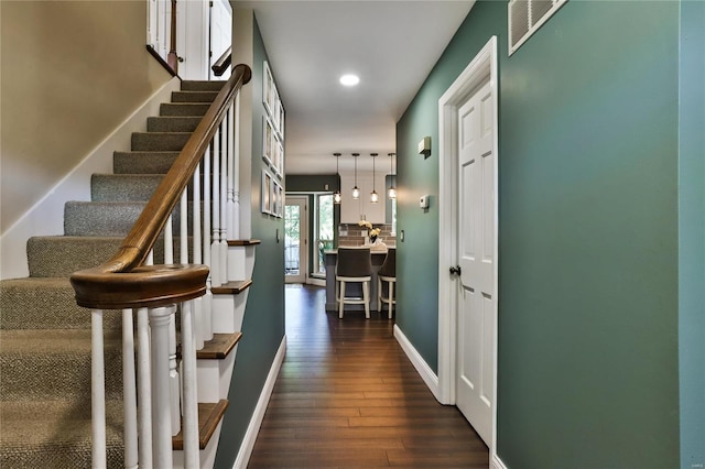 hall with visible vents, dark wood finished floors, recessed lighting, baseboards, and stairs