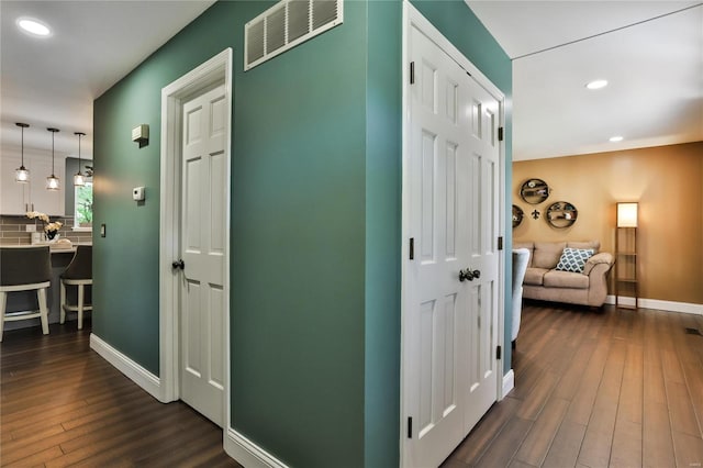 hall with recessed lighting, visible vents, baseboards, and dark wood-style floors