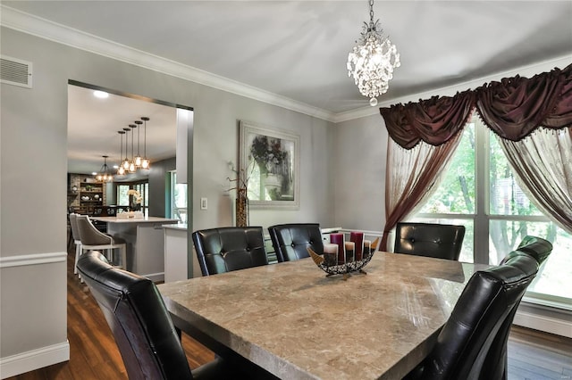 dining area featuring visible vents, dark wood-type flooring, an inviting chandelier, and ornamental molding