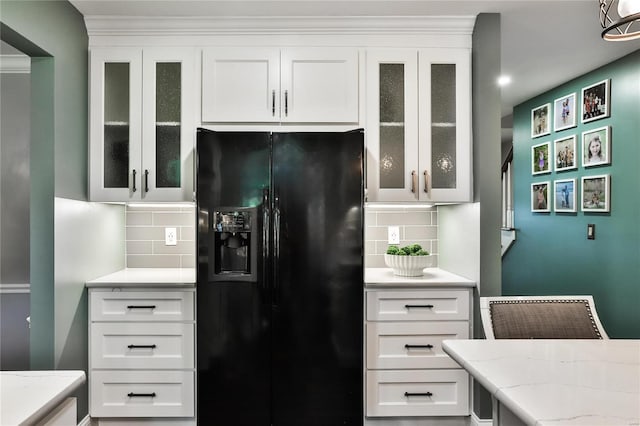 kitchen featuring white cabinetry, black fridge with ice dispenser, and backsplash