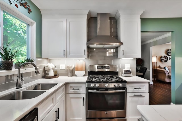 kitchen with dishwashing machine, stainless steel range with gas cooktop, a sink, wall chimney exhaust hood, and tasteful backsplash