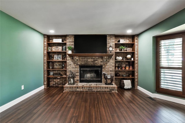 unfurnished living room featuring visible vents, a brick fireplace, wood finished floors, and baseboards