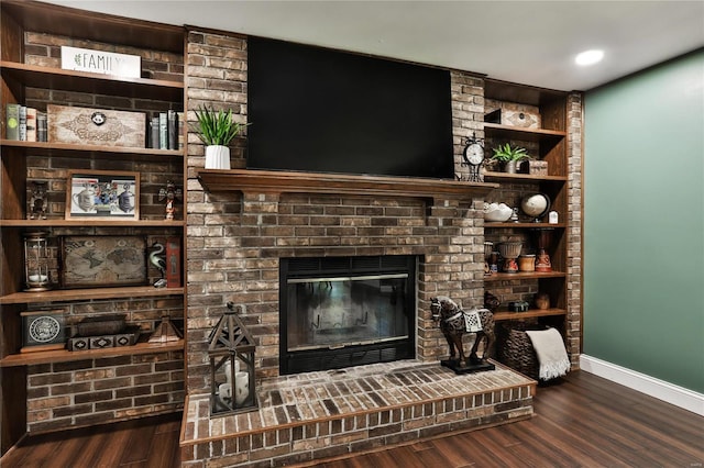 living room with wood finished floors, a fireplace, and baseboards