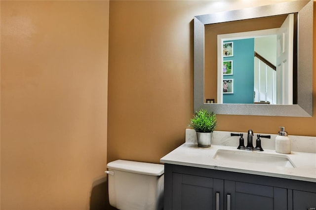 half bathroom with vanity and toilet