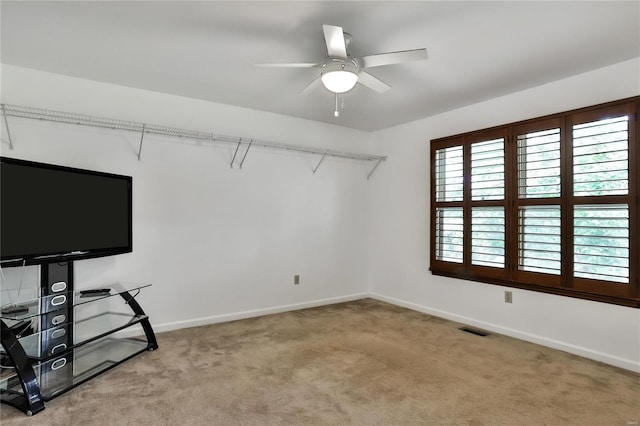 interior space with baseboards, visible vents, and ceiling fan