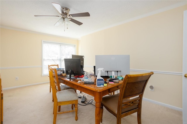 office area featuring baseboards, light colored carpet, ornamental molding, and a ceiling fan