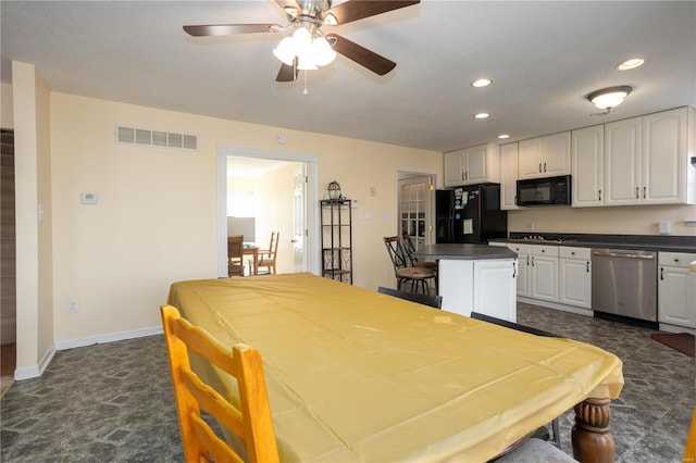 interior space with visible vents, dark countertops, black appliances, and white cabinetry