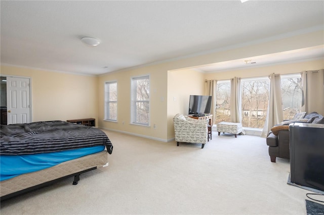 carpeted bedroom with crown molding and baseboards