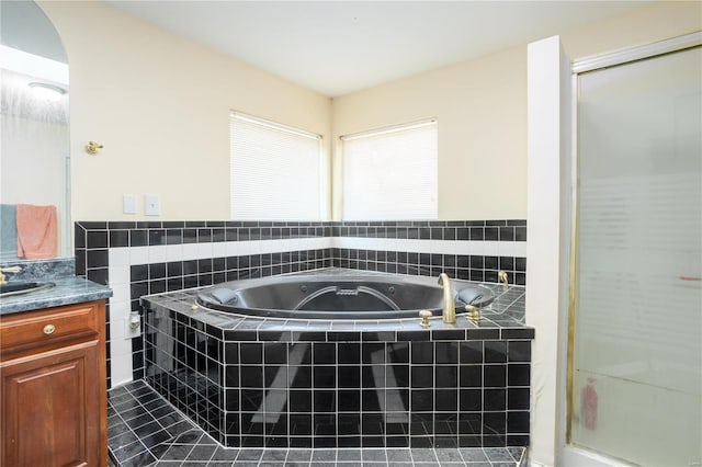 bathroom featuring tile walls, a shower stall, tile patterned flooring, a bath, and vanity