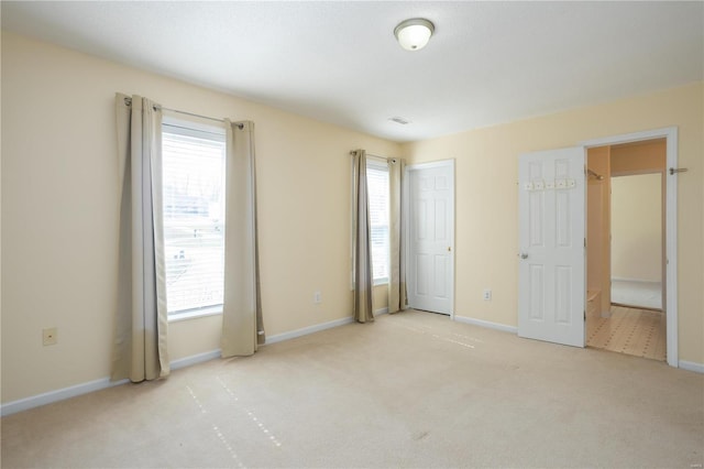 unfurnished bedroom featuring multiple windows, baseboards, and carpet