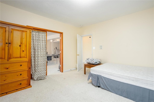 bedroom with light carpet and baseboards