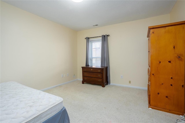 carpeted bedroom with visible vents and baseboards