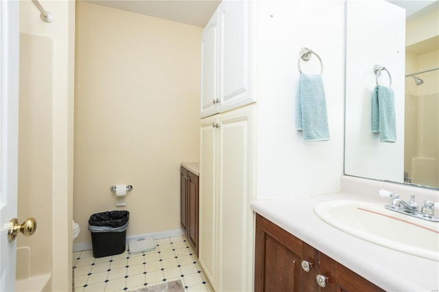 full bathroom with vanity, baseboards, walk in shower, tile patterned floors, and toilet