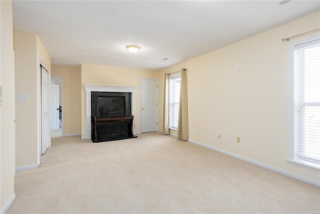 unfurnished living room featuring light colored carpet, a fireplace, and baseboards