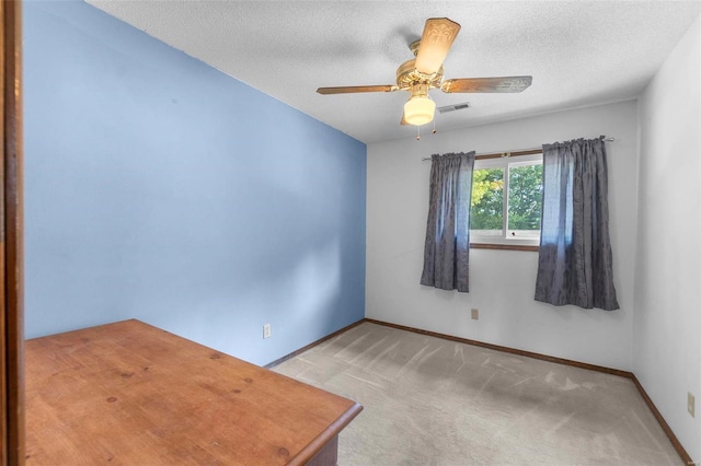 carpeted spare room featuring ceiling fan, baseboards, visible vents, and a textured ceiling