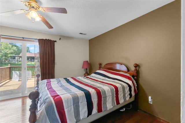 bedroom with visible vents, access to exterior, a textured ceiling, wood finished floors, and ceiling fan