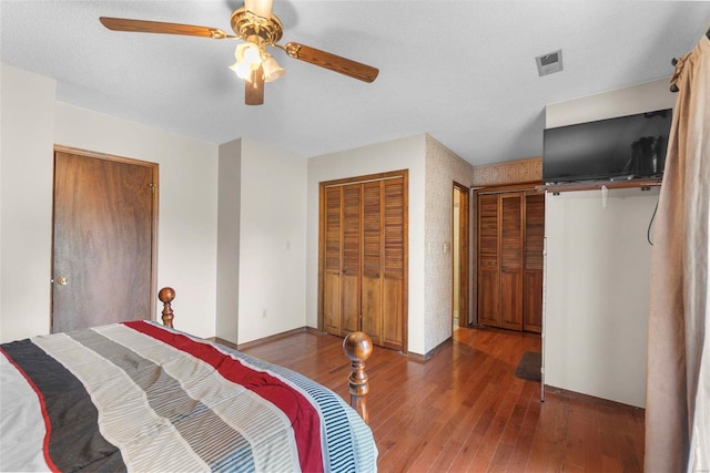 bedroom with a ceiling fan, visible vents, wood finished floors, and baseboards