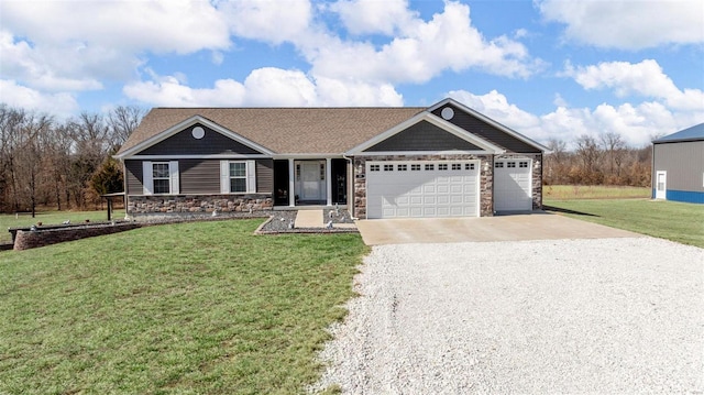 view of front of house with gravel driveway, a front lawn, an attached garage, and stone siding