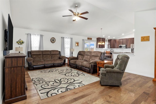 living room featuring a wealth of natural light, baseboards, ceiling fan, and wood finished floors