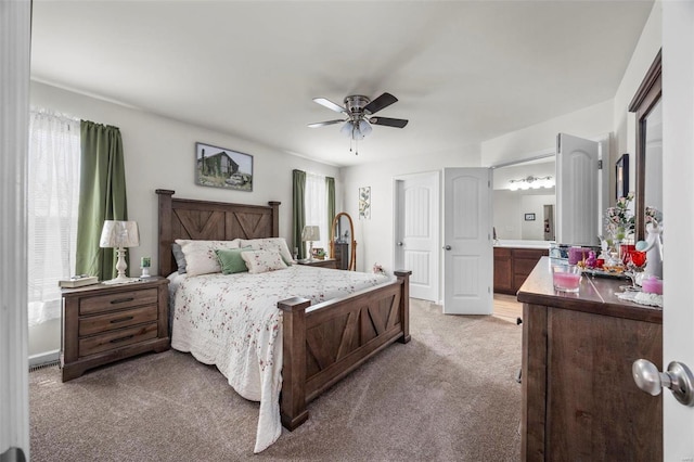 bedroom with light colored carpet, ensuite bathroom, and ceiling fan