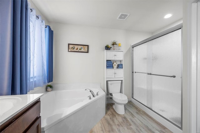 full bathroom with visible vents, a garden tub, toilet, wood finished floors, and a shower stall