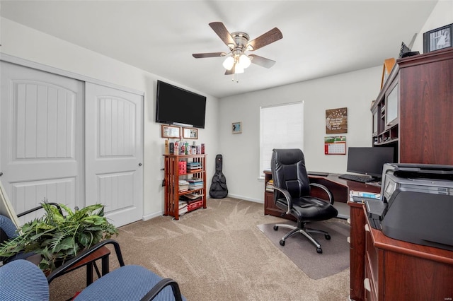 office featuring baseboards, light colored carpet, and ceiling fan