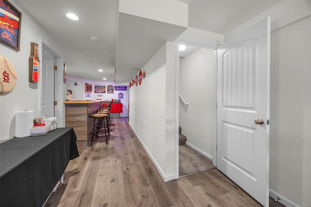 hallway featuring recessed lighting, baseboards, stairs, and light wood finished floors