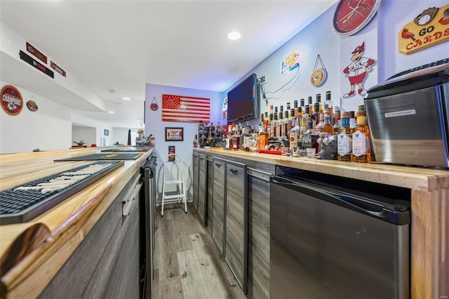 bar with recessed lighting, a bar, and light wood finished floors