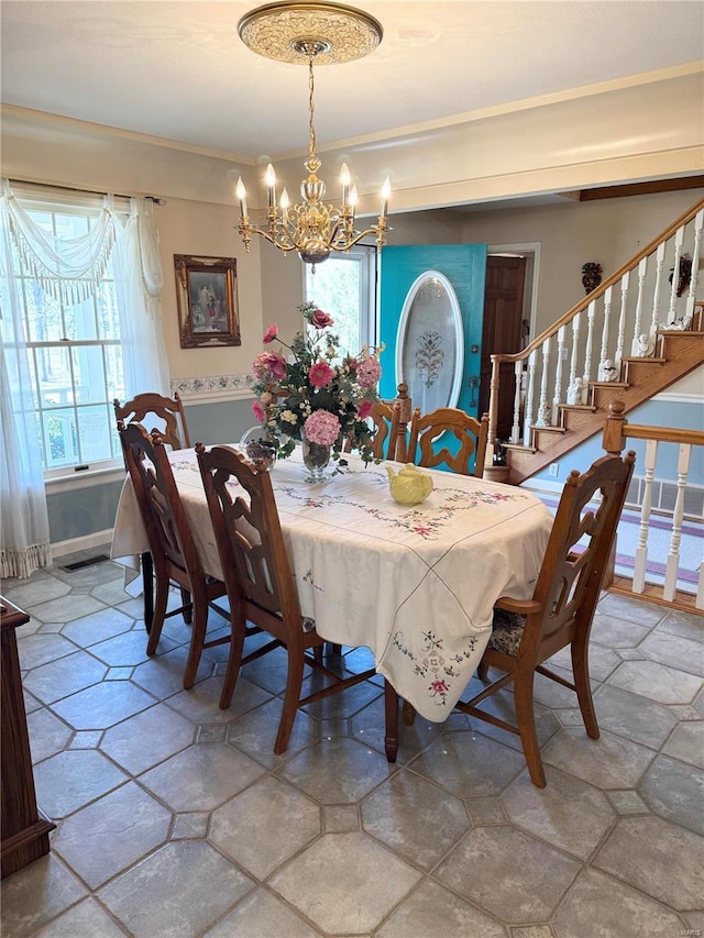 dining space featuring stairway, a notable chandelier, a healthy amount of sunlight, and stone tile flooring